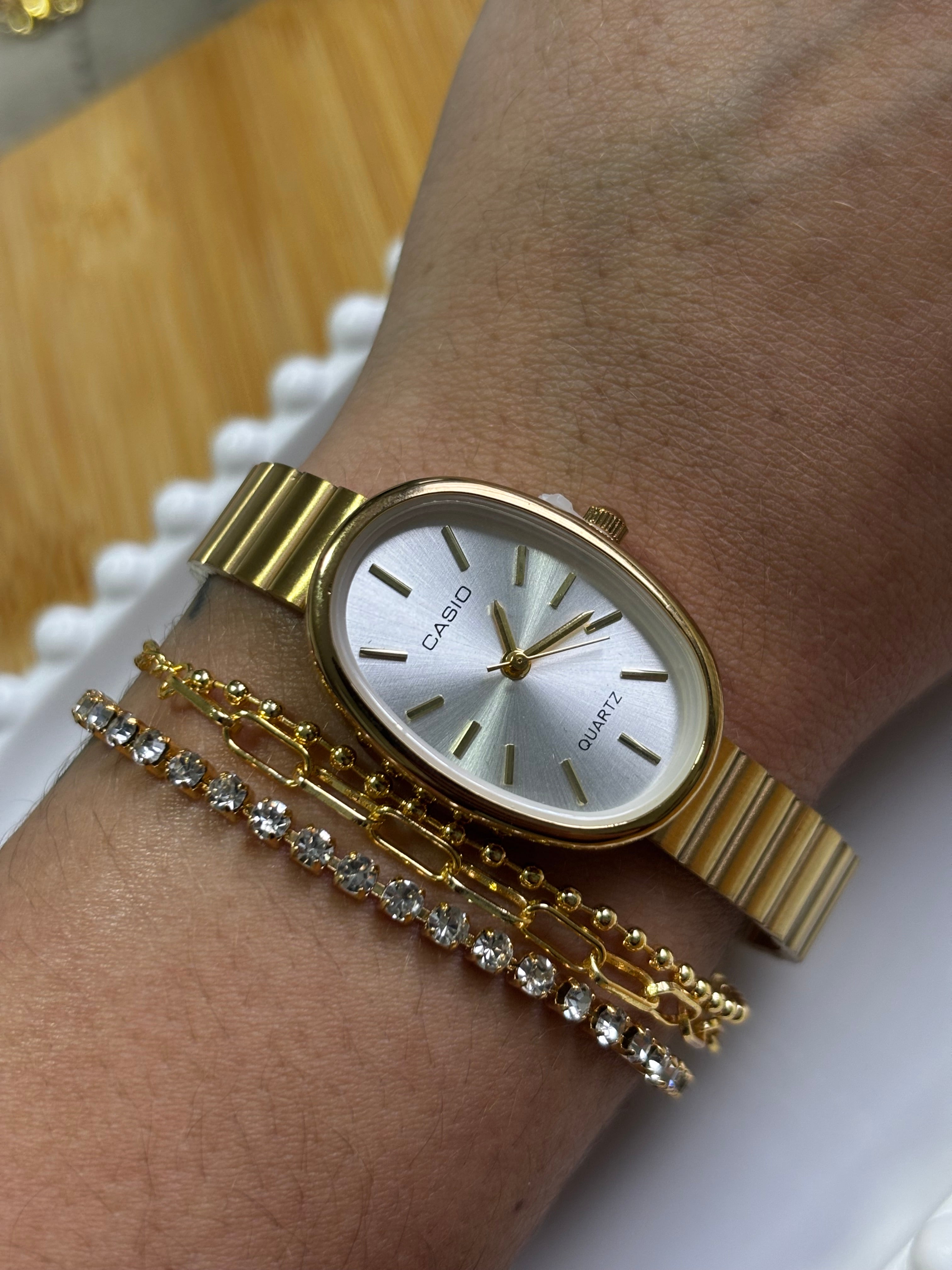 Relógio Cássio dourado oval fundo neutro